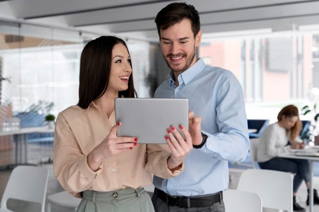 Man and woman holding tablet in office illustrates blog "What Is Business Property Insurance?"