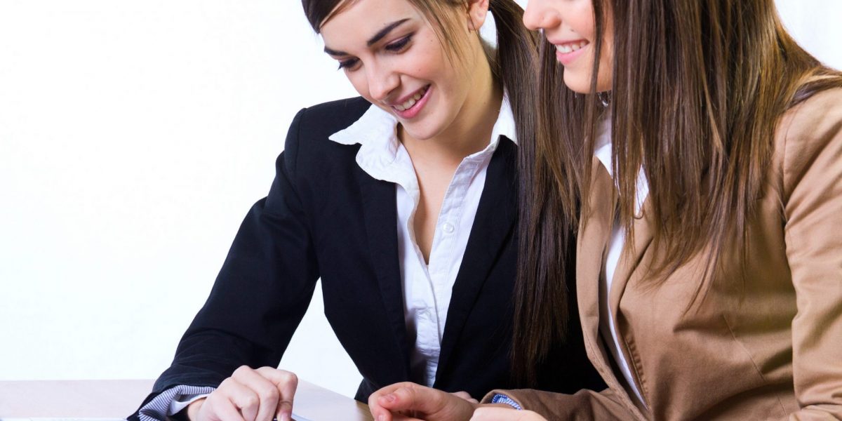 Two women looking at documents illustrate blog "The Importance of Having an HR Consultant"