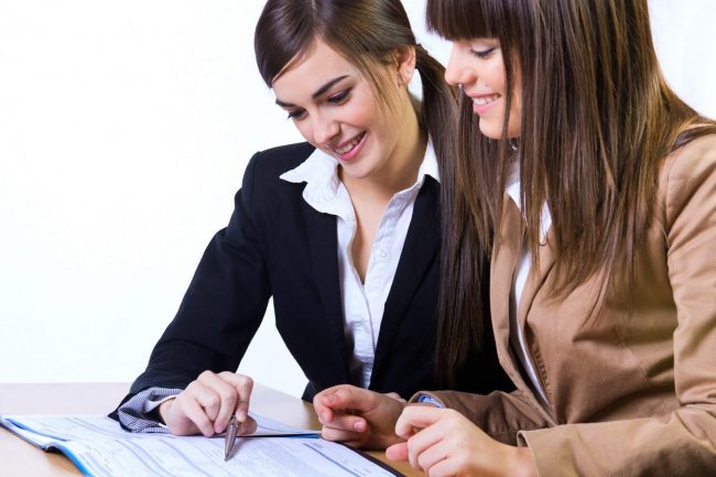 Two women looking at documents illustrate blog "The Importance of Having an HR Consultant"