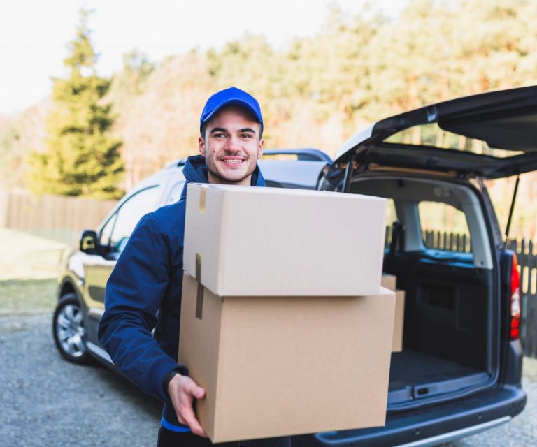 delivery-van-FP2 Man carrying boxes in front of delivery van illustrates blog "Is Commercial Auto Insurance Required in California?"