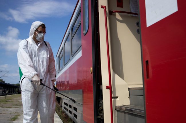 Man in hazmat suit by truck illustrates blog "What Is Hazmat Truck Insurance?"